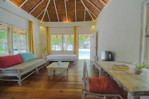 een woonkamer met een bank en een tafel bij Trikora Beach Club and Resort in Telukbakau