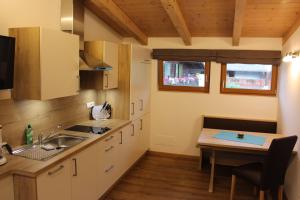 a kitchen with a sink and a table at Appartements Pixner in Saltusio