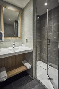 a bathroom with a tub, toilet and sink at Premiere Classe Clermont Ferrand Centre in Clermont-Ferrand