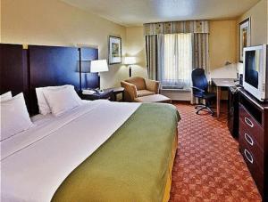 Habitación de hotel con cama grande y escritorio. en Holiday Inn Express Hotel & Suites Muskogee, an IHG Hotel, en Muskogee