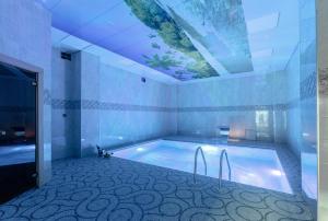 a bathroom with a large swimming pool with a ceiling at ISMAYILLI RESORT HOTEL in İsmayıllı