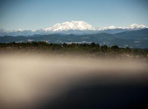 a view of snow covered mountains with a misty lake at Hotel Locanda Dei Mai Intees in Azzate