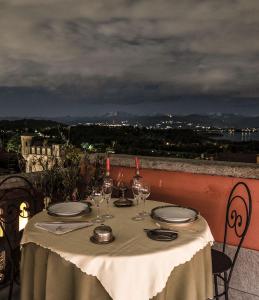 Hotel Locanda Dei Mai Intees في Azzate: طاولة مع أطباق وكؤوس للنبيذ على شرفة
