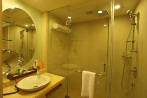 a bathroom with a glass shower and a sink at Comfort Inn Legacy in Rajkot
