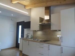 una cocina con armarios blancos y fregadero en Appartements Pixner en Saltusio