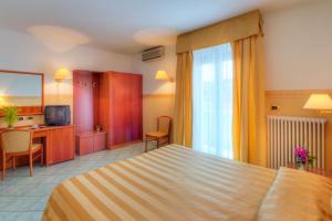 una camera d'albergo con letto e scrivania di Hotel Il Caminetto a Porto San Giorgio