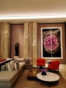 un soggiorno con divano e un dipinto a fiori di Casa Grande Residence Tower Angelo a Giacarta