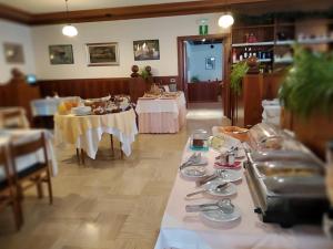 a dining room with two tables with plates and silverware at Hotel Garnì Miramonti in Falcade