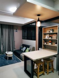 a living room with a table and a couch at Casa Grande Residence Tower Angelo in Jakarta