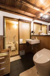 a bathroom with a toilet and a sink and a tub at Machiya Kanazawa Kikunoya in Kanazawa