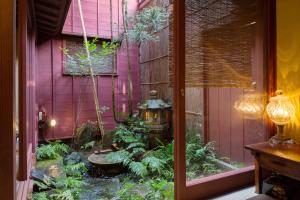 a garden in front of a pink house with a fountain at Machiya Kanazawa Kikunoya in Kanazawa