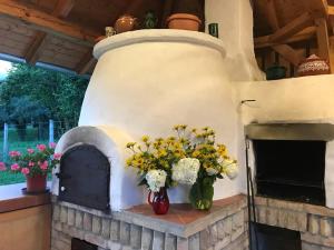 un horno de ladrillo con un ramo de flores en un jarrón en Nomád jurta Zalakaros mellett, en Zalamerenye