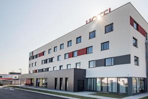 a white building with the sun shining on it at ATOLON PARK HOTEL in Brumath