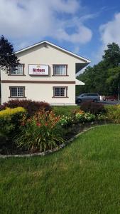 a white building with a sign on the side of it at Atrium Inn & Suites in Galloway