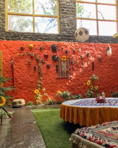 ceglana ściana ze stołem i kwiatami w obiekcie Hotel Yac Donalds w mieście Kāgbeni