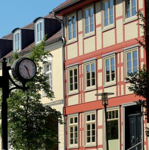 une horloge sur un pôle devant un bâtiment dans l'établissement Ferienwohnung Burgplatz 1, à Plau am See