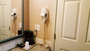a bathroom with a hair dryer and a mirror at Atrium Inn & Suites in Galloway