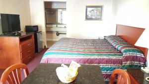 Habitación de hotel con cama y mesa en Atrium Inn & Suites en Galloway