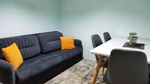 - un salon avec un canapé bleu et des oreillers jaunes dans l'établissement Cozy&Comfy Apartment in the Center of Prishtina, à Pristina