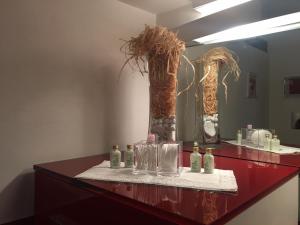 a red counter with two vases and a mirror at Feeling at Home - Varese Apartment in Varese +42 photos