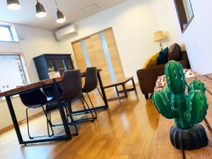 ein Wohnzimmer mit einem Tisch und einem Kaktus in der Unterkunft Cactus Inn in Miyazaki