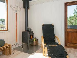 a living room with a stove and a chair at 4 person holiday home in Fan in Fanø