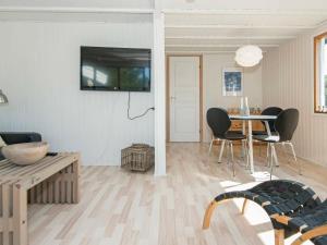 sala de estar con mesa, sillas y TV en 4 person holiday home in Fan, en Fanø