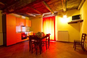 a kitchen with a table and chairs in a room at La Locanda Dei Cartunè in Montezemolo