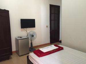 Quang Tri的住宿－Khách sạn nam đông，一间卧室配有一张床、一个风扇和一台电视。