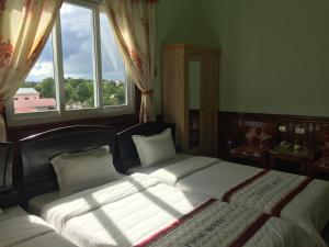 Quang Tri的住宿－Khách sạn nam đông，一间卧室设有两张床和窗户。