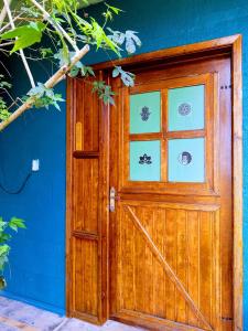a wooden door of a house with a blue wall at Vila Ecológica Pousada Holística in Cambará
