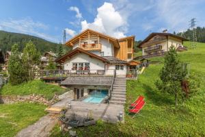 a house on a hill with a swimming pool at Arnica Mountain Hotel in Soraga