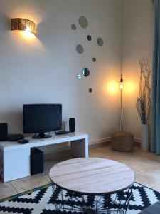 een woonkamer met een tafel en een tv bij Le Panorama in Fréjus +32 foto's