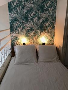 een slaapkamer met een bed met tropisch behang bij Le Panorama in Fréjus