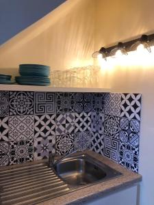 een wastafel in een keuken met tegels op de muur bij Le Panorama in Fréjus