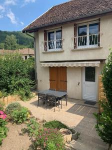 une maison avec une table et des chaises dans la cour dans l'établissement La grange de mémé Yvette, à Vaulnaveys-le-Haut