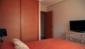 a bedroom with a bed and a television on a dresser at Okeanos sea view 1 bedroom VR-S in Granadilla de Abona