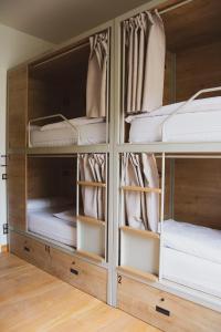 a wooden cabinet with four shelves with mattresses at A Room In The City Hostel in San Sebastián