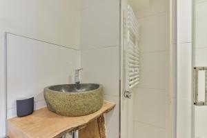 a bathroom with a stone sink on a wooden table at Luxury Beach Studio Zandvoort in Zandvoort +20 photos
