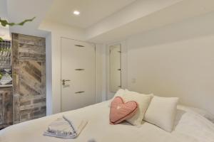 a white bed with a heart pillow on it at Luxury Beach Studio Zandvoort in Zandvoort