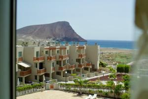 a view of a building with the ocean in the background at Okeanos sea view 1 bedroom VR-S in Granadilla de Abona