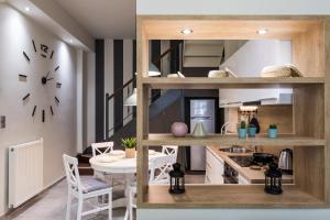 modern city center maisonette في يوانينا: مطبخ وغرفة طعام مع طاولة وساعة