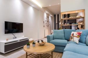 un soggiorno con divano blu e tavolo di modern city center maisonette a Ioannina