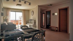 a living room with a table and chairs and a kitchen at Okeanos sea view 1 bedroom VR-S in Granadilla de Abona