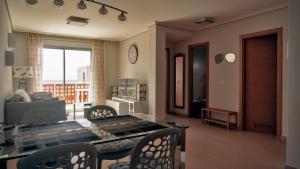 グラナディージャ・デ・アボナにあるOkeanos sea view 1 bedroom VR-Sのリビングルーム(テーブル、椅子付)、キッチン