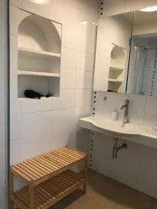 a bathroom with a sink and a mirror and a bench at VOILES ST TROPEZ APARTEMENTS in Saint-Tropez