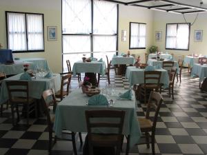 a room with tables and chairs with blue tablecloths at Hotel Villa Flora in Roncegno +27 photos