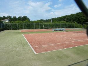 a tennis court with a bench on top of it at Vakantiewoning Seaewald in Zeewolde