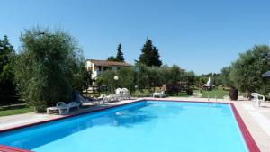 una gran piscina con sillas y una casa en Agriturismo Podere Sottogello, en San Giovanni a Corazzano 