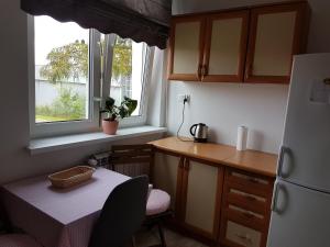 a small kitchen with a table and a refrigerator at Apartament przy plaży in Mikołajki
